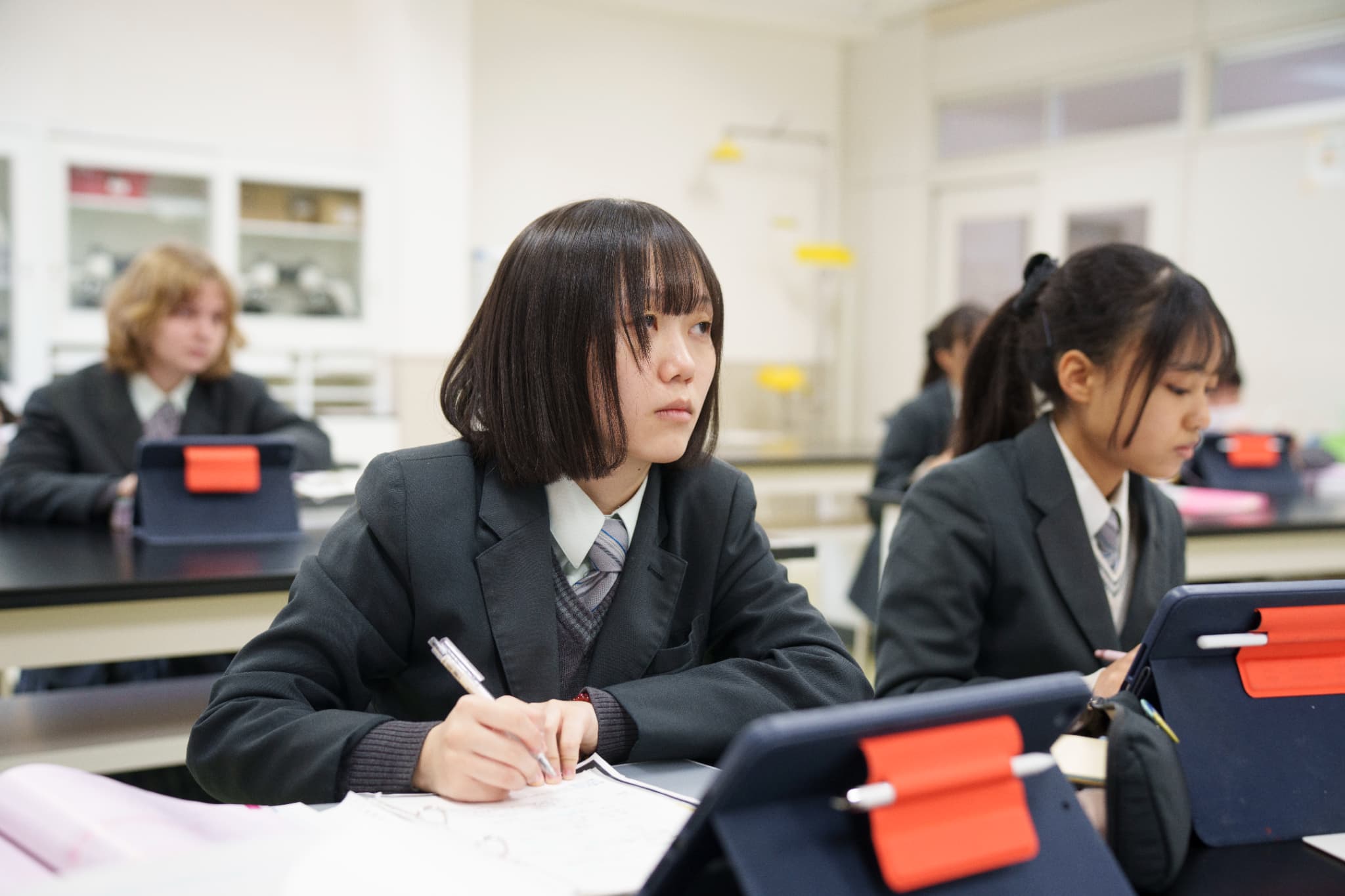 制服を着た学生たちが授業を受ける様子